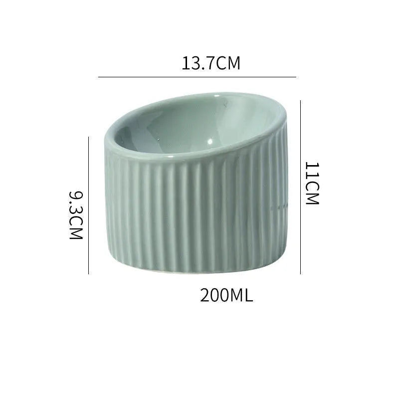 Ceramic raised cat bowl with tilted design in green colour on wooden surface
