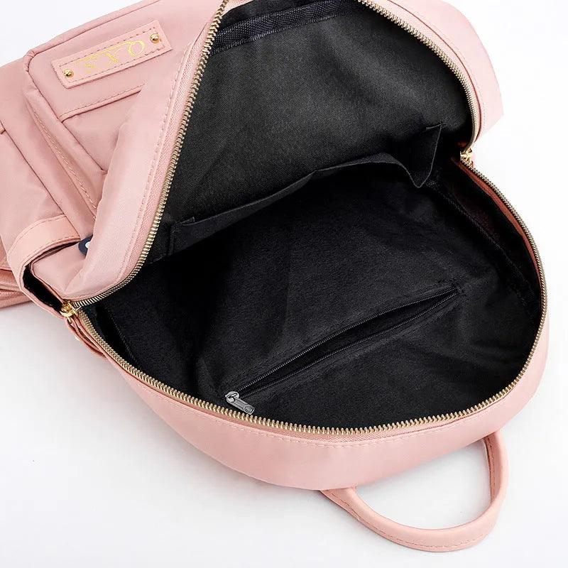 Women's black nylon casual backpack with double shoulder straps, soft handle, and front pocket.