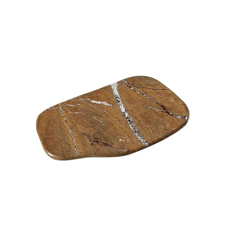 Irregular natural marble tray in coffee colour on a wooden coffee table with decorative objects
