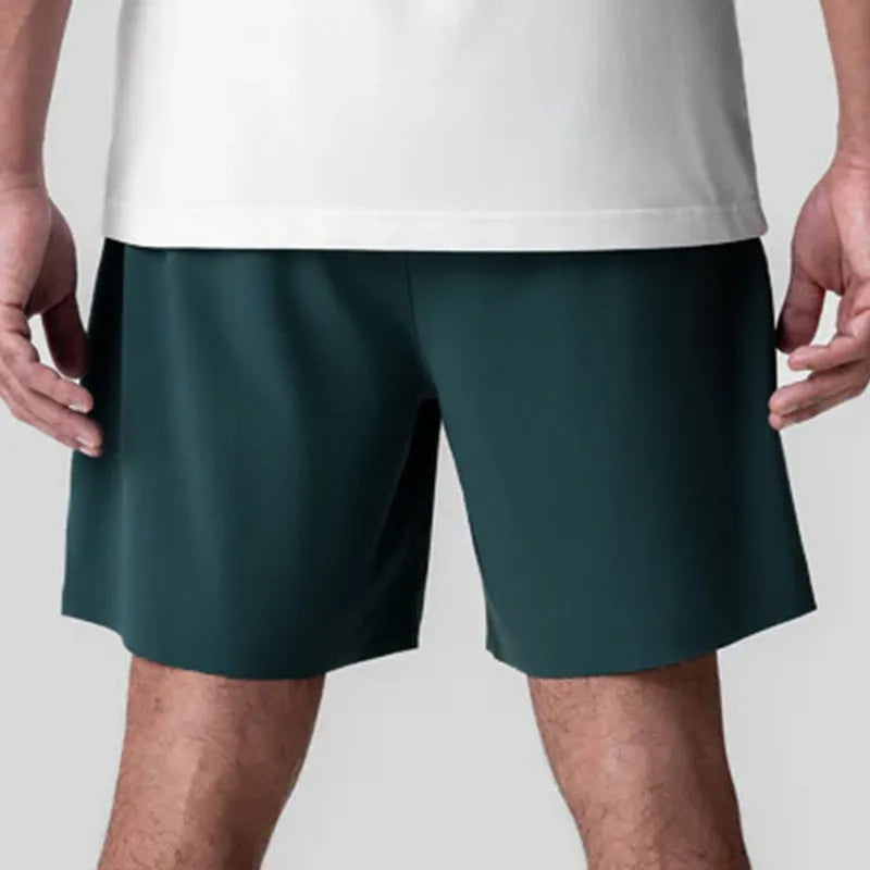 Men's quick-drying polyester sports shorts in knee length with multi-bag design, black colour, front view