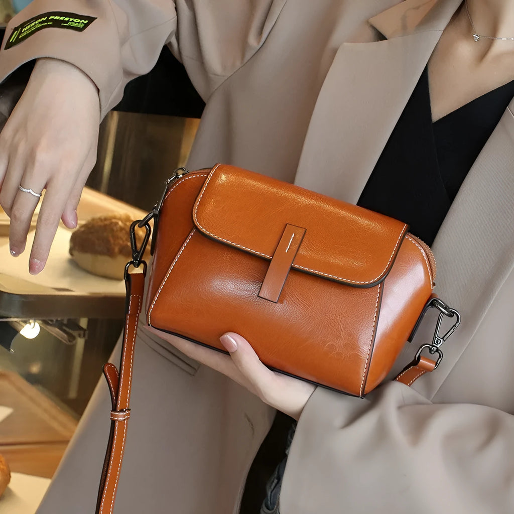 Women's brown shell-shaped messenger bag in oil wax leather with cross-body strap and organised interior