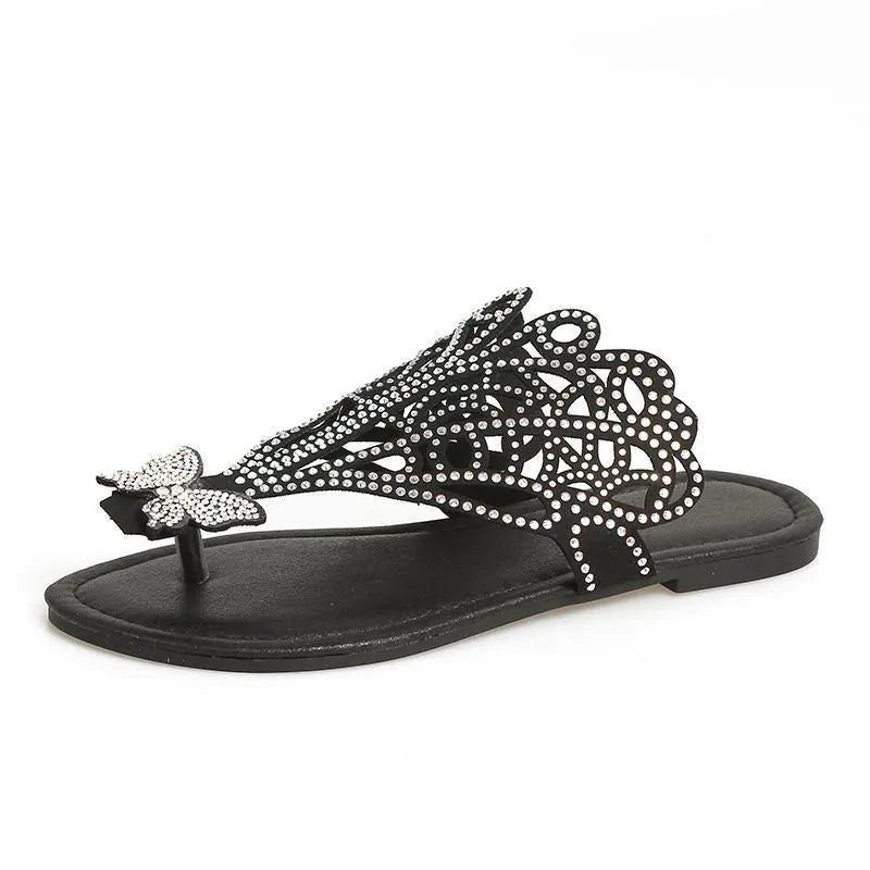 Women's black slip-on sandals with rhinestone accents and flip-toe design on flat rubber sole