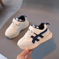 Children's white velcro sneaker with synthetic leather upper and rubber sole on a neutral background.