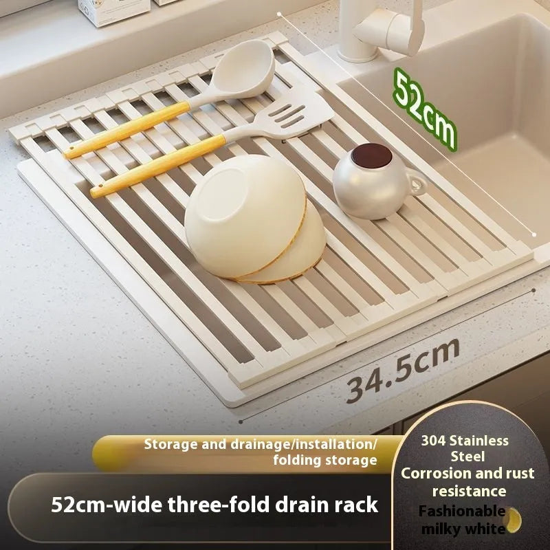 Milky white foldable stainless steel kitchen draining rack placed next to a sink.