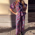 Women's floral printed trousers suit with tie-neck top featuring puff sleeves and matching trousers