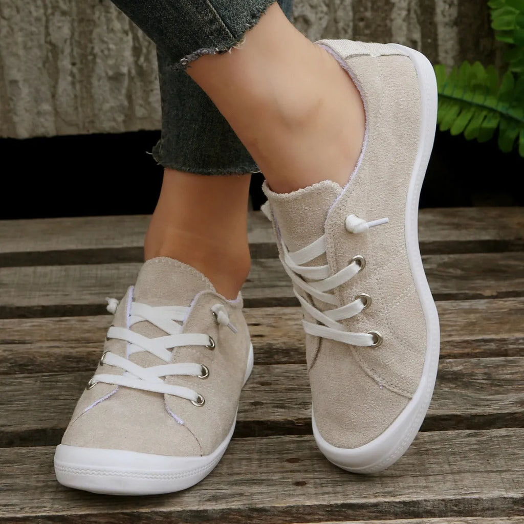 Women's creamy white fabric casual sneakers with rubber soles showing low-top design