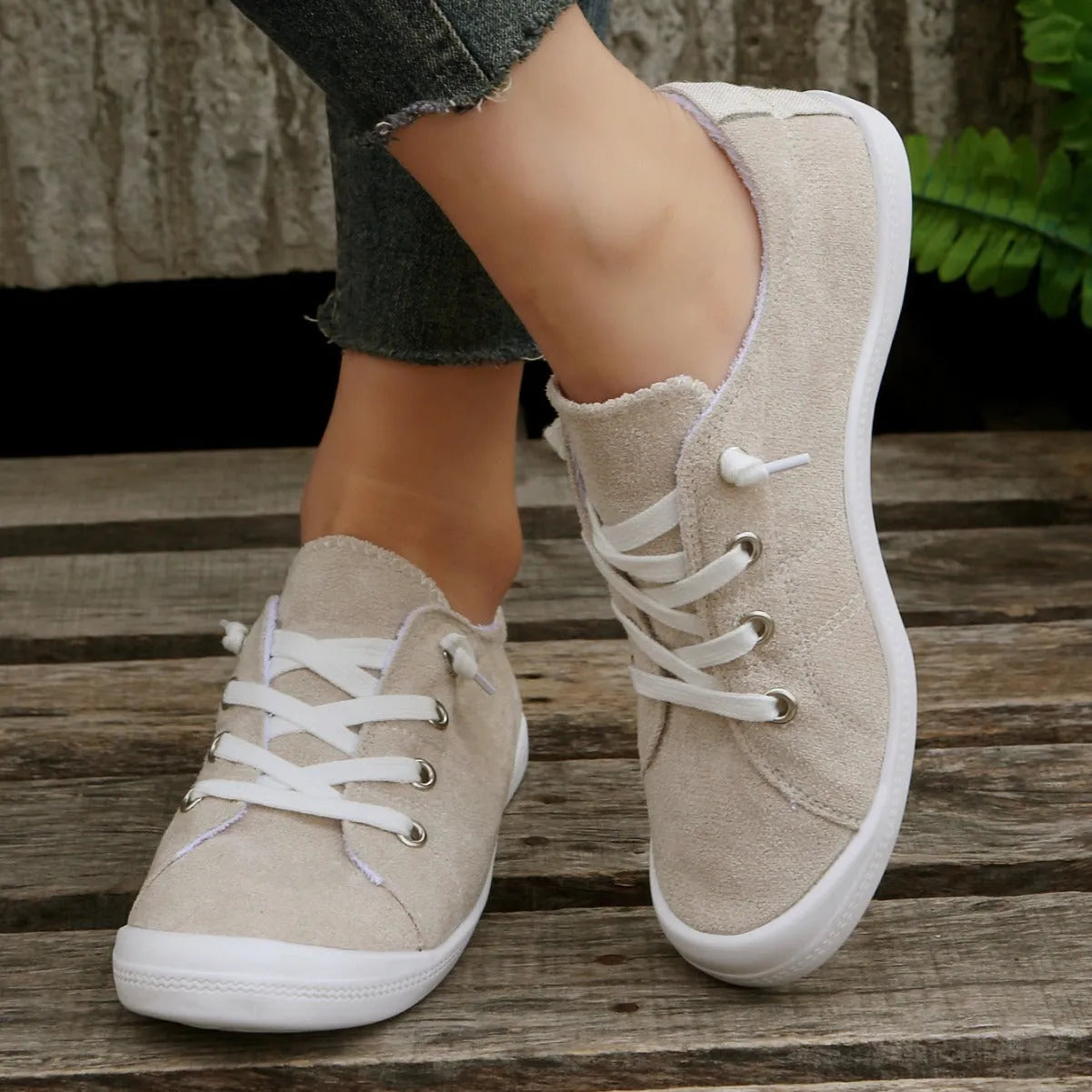 Women's creamy white fabric casual sneakers with rubber soles showing low-top design