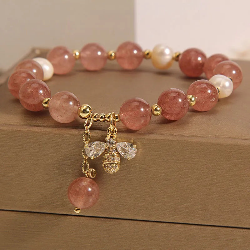 Women's beaded bracelet with strawberry quartz stones, freshwater pearls, and zircon accents on alloy.