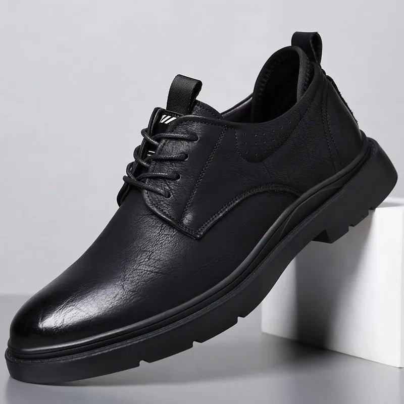Men's black and brown leather shoes with rubber sole and sewn detailing on a white background.