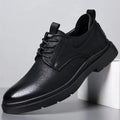 Men's black and brown leather shoes with rubber sole and sewn detailing on a white background.