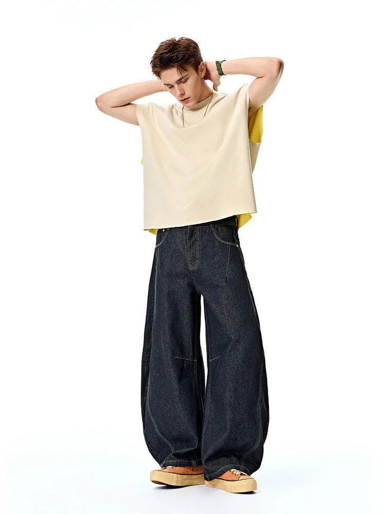 Men's original cow colour wide-leg denim trousers laid flat, showing mid-waist and full-length legs.