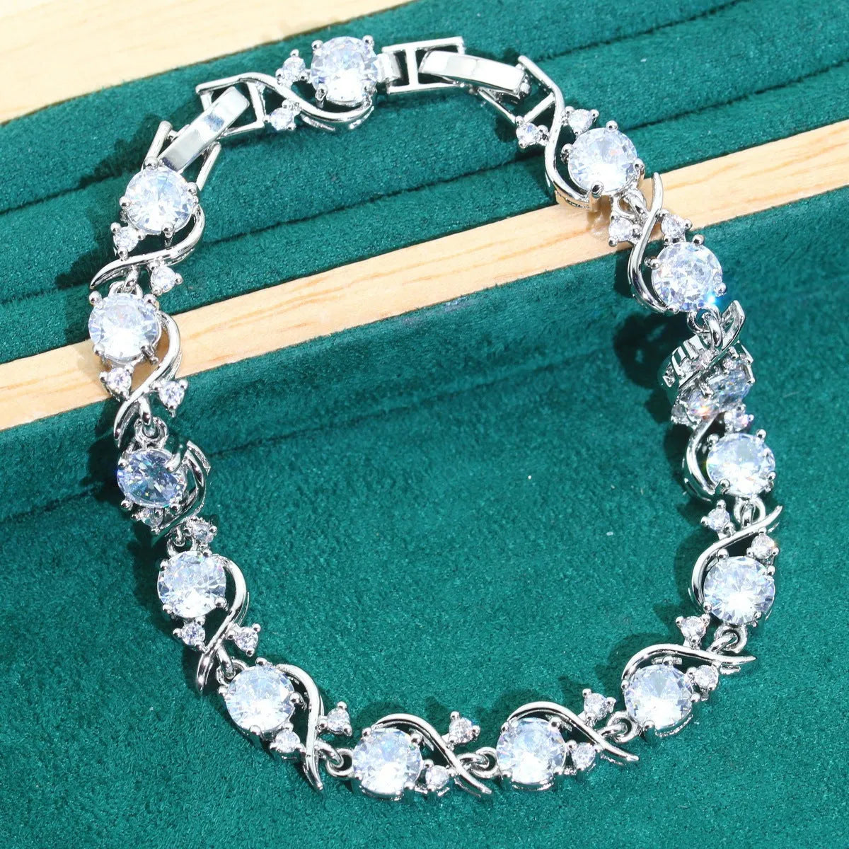 Bridal jewellery four-piece set with zircon pendants showing necklace, bracelet, earrings and ring with water wave chain design