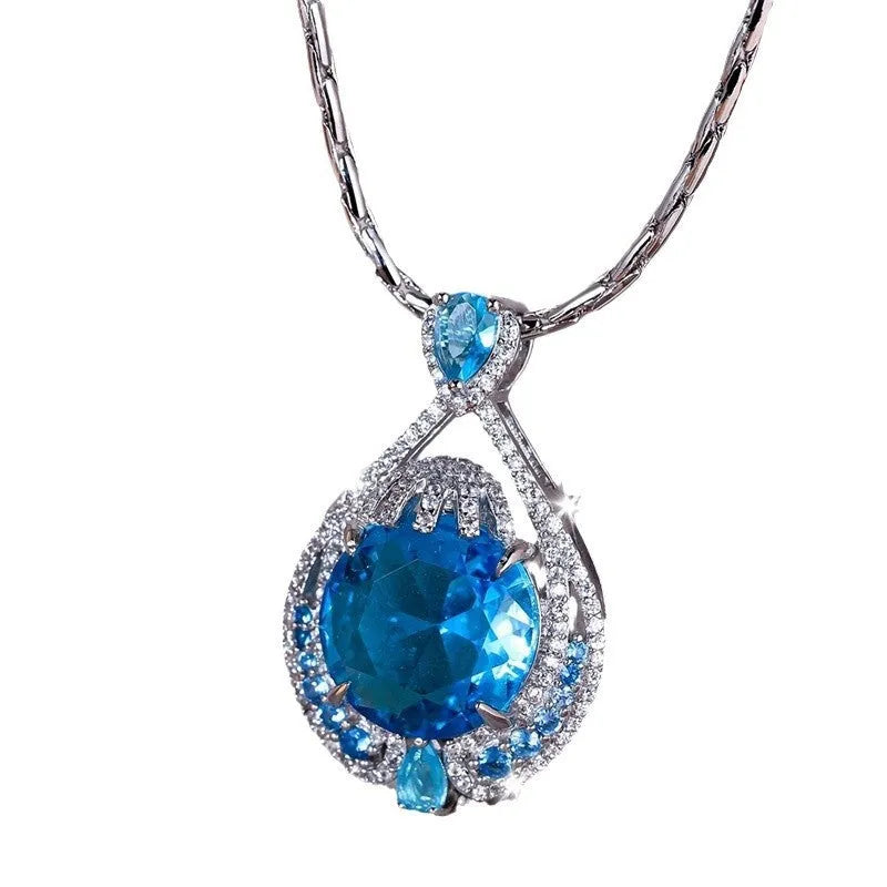 Close-up of a women's geometric necklace with a blue crystal pendant on a water wave chain.