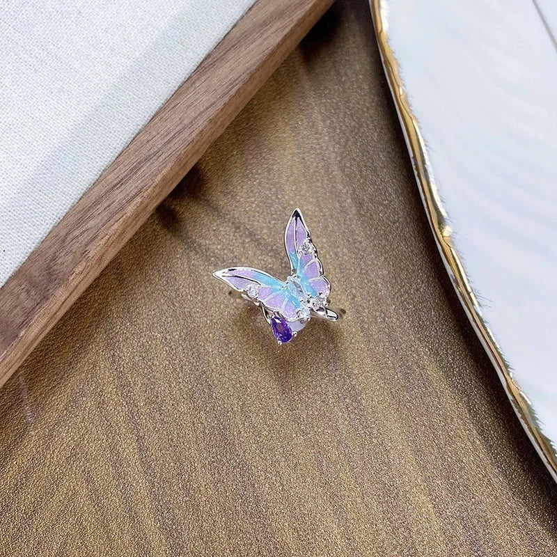 Close-up of an adjustable copper ring with sculptural insect design and a drip-oil texture finish.