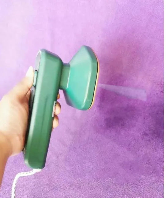 Dark green portable handheld hanging steam ironing machine with ceramic panel on a white background.