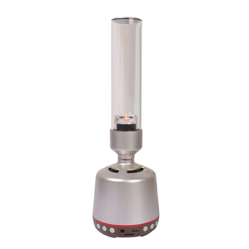 White silver Bluetooth speaker with integrated candlelight atmosphere night light on a table.