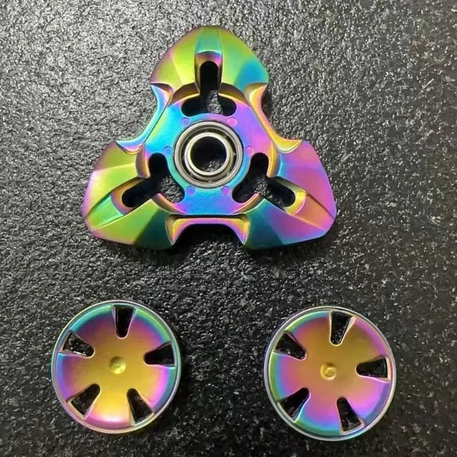Alloy decompression fingertip gyro toy in gun colour finish on a dark background