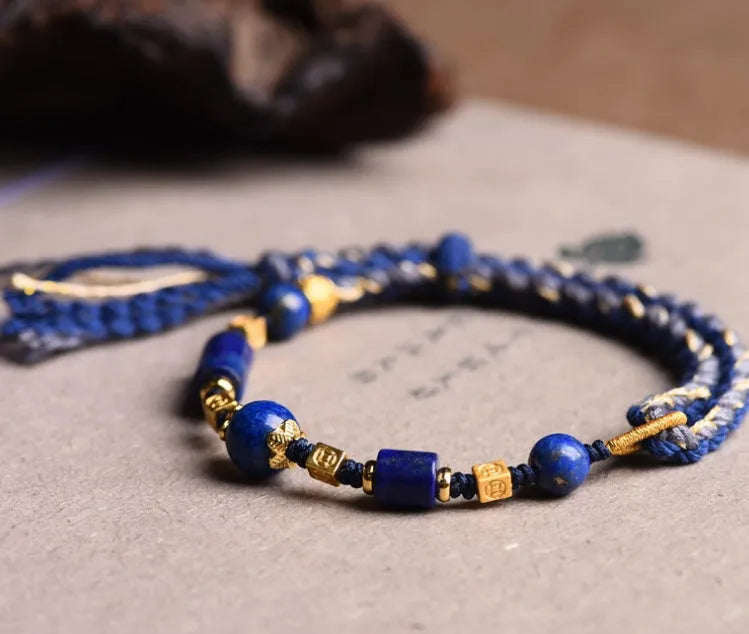 Hand-woven lapis lazuli flexible wire bracelet with simple ethnic design on white background