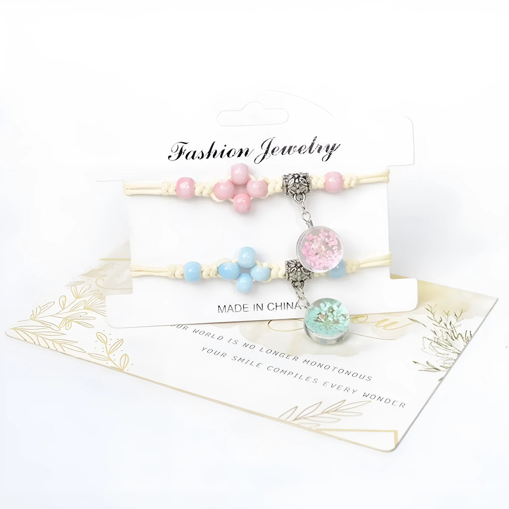 Close-up of a women's glass bracelet with large 1.4cm beads containing dried flowers and a hand-woven lace pattern.