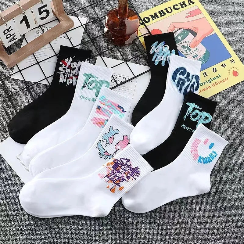 White cotton tube socks with graffiti pattern and middle calf length on plain background