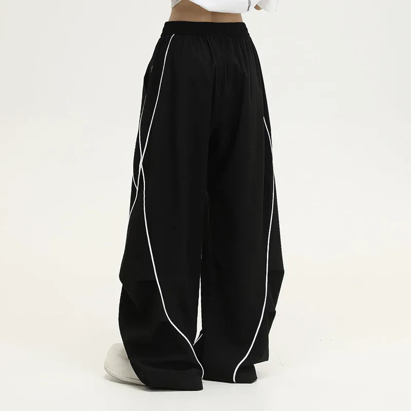 Black pleated wide-leg sports trousers with vertical stripe pattern and mid waist