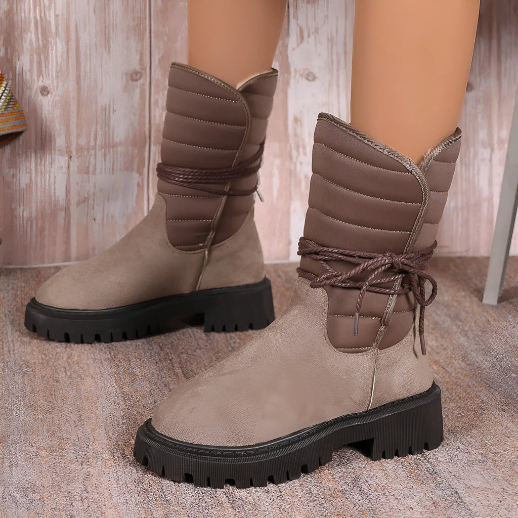Women's black chunky heel snow boot with lace-up design and suede upper on a white background.