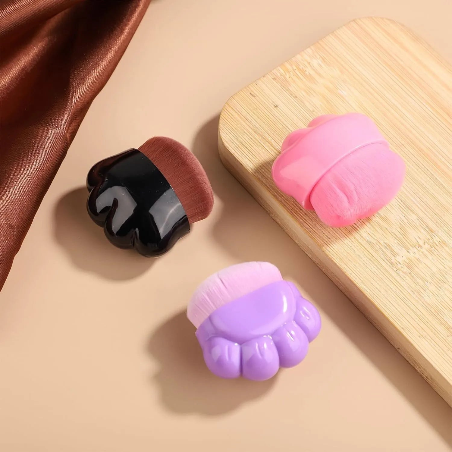 Three dog paw balm brushes with soft fibre heads and paw-shaped plastic handles, each in a small clear storage box