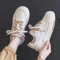 Beige and pink low-top sneaker with a height-increasing rubber sole on a white background