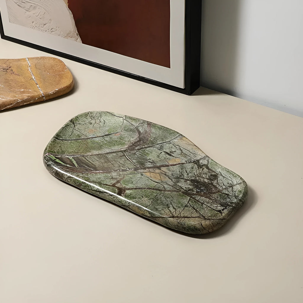 Irregular natural marble tray in coffee colour on a wooden coffee table with decorative objects