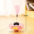 Pink cat tumbler turntable toy with rotating base and attached stick on white background