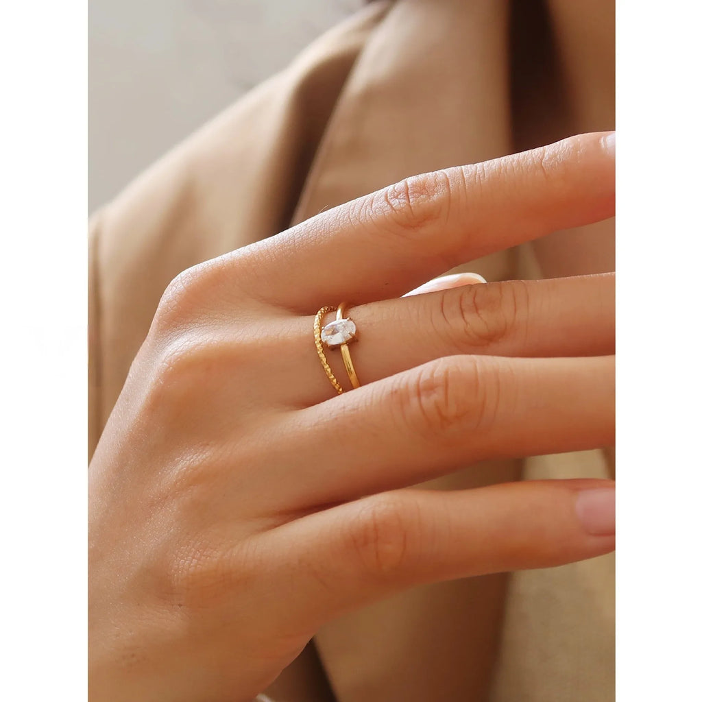 Golden stainless steel ring with heart shape on oval band, shown in size options 5 through 8