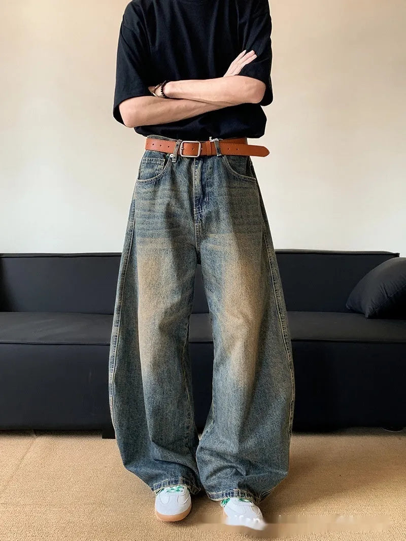 Men's retro blue distressed denim trousers with wide leg cut and vintage wash detailing