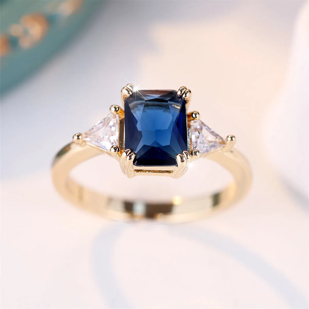 Ladies rectangular copper fashion ring in gold sapphire blue finish on finger