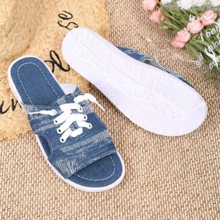 Blue women's Roman style flat canvas slippers with a cloth upper and rubber sole.