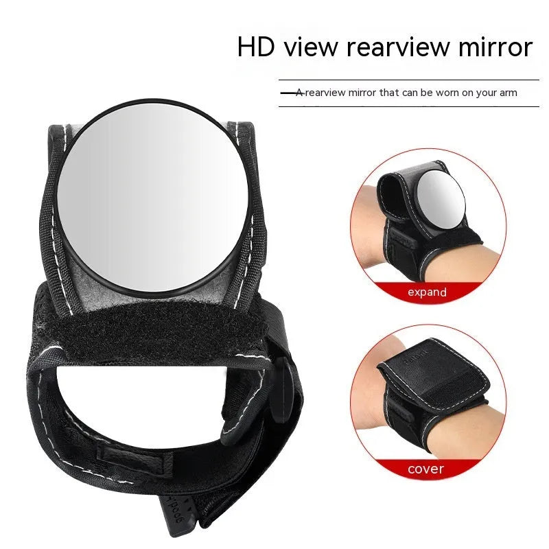 Black nylon wrist-mounted bicycle rear-view mirror shown on a cyclist's wrist.