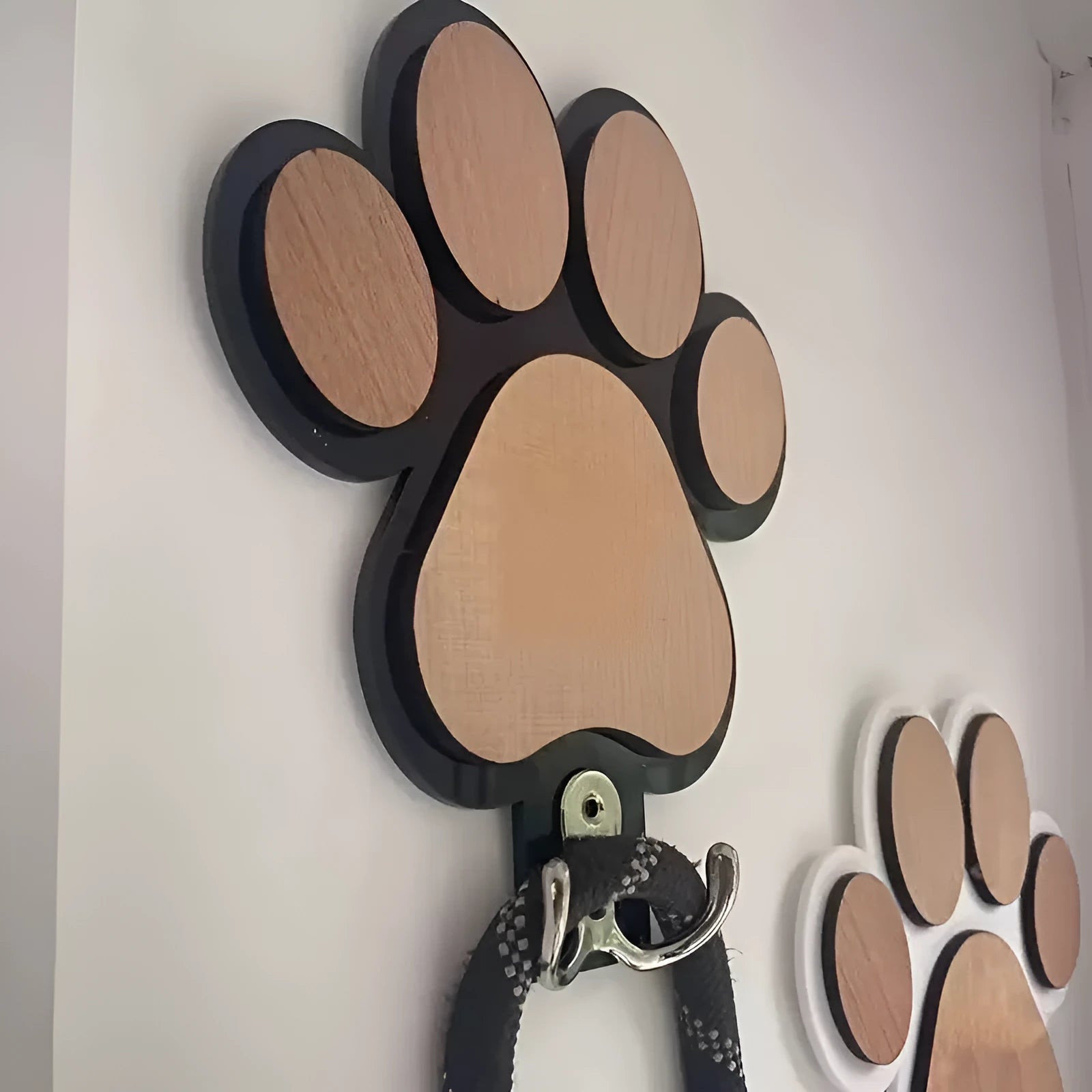 Wooden foot paw print wall hook in black finish, modern simplicity style, with a coat hanging from it