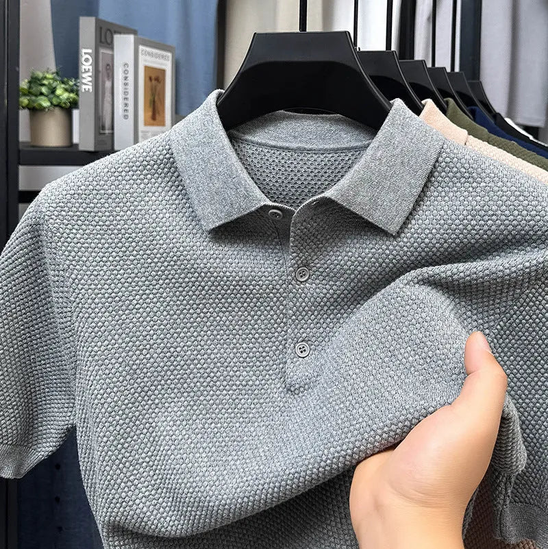 A loose short-sleeved cotton pullover sweater on a hanger, shown in a solid colour.