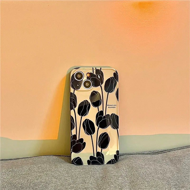 Black silicone iPhone case with a white tulip floral graphic on the back