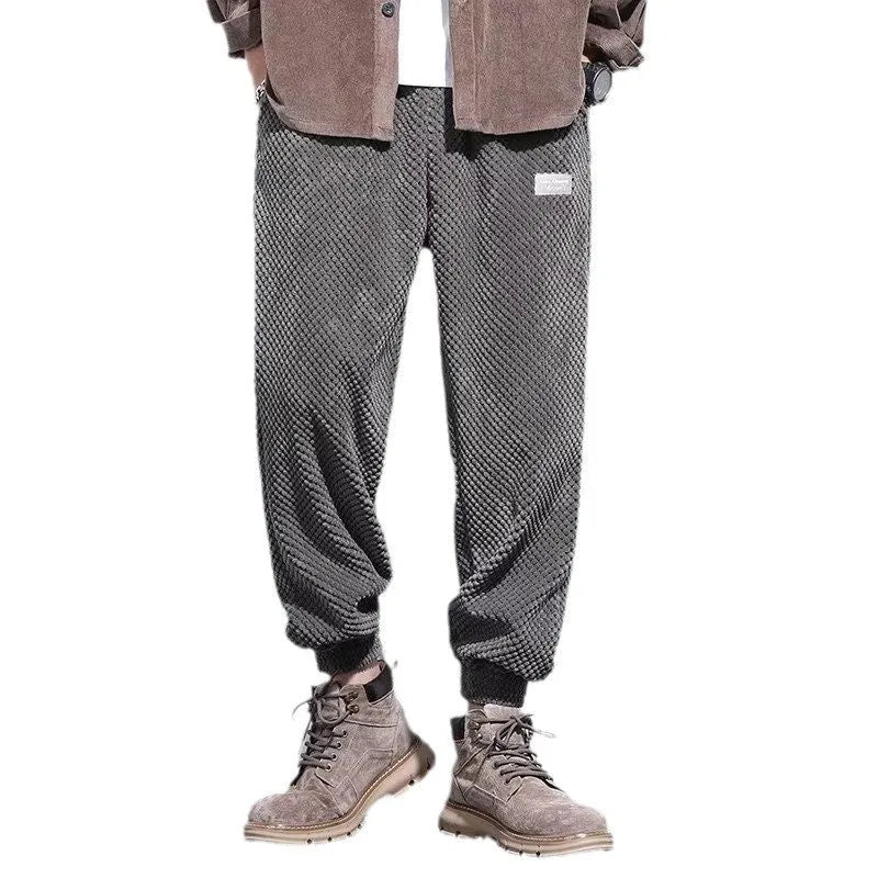 Grey men's casual sweatpants with ankle tie fastening and straight leg on a neutral background.