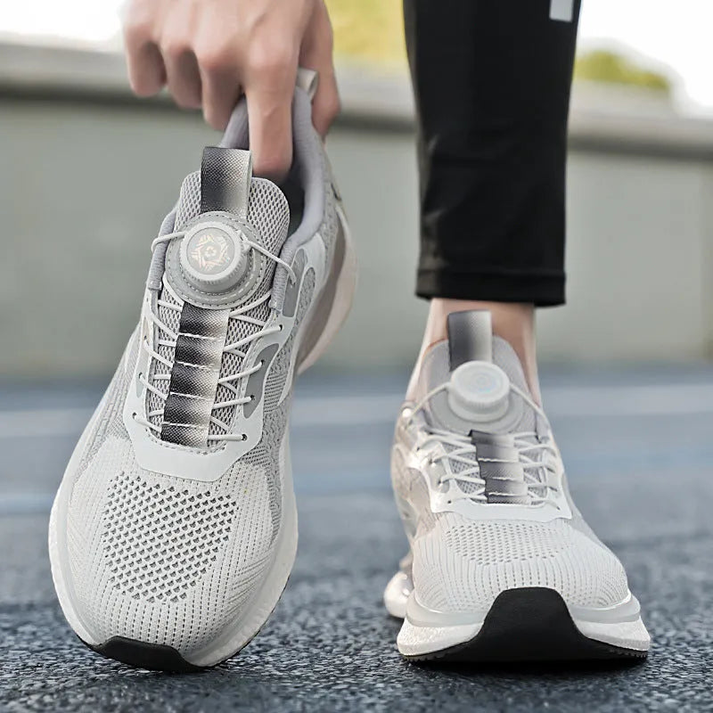 Men's white low-top running shoe with a rotating silver buckle on a grey background.