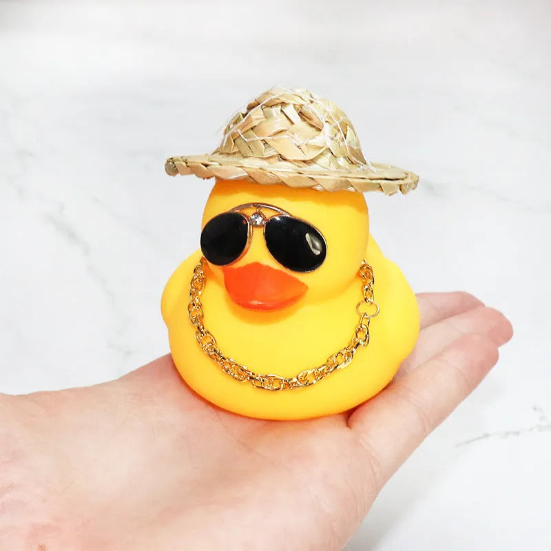 Yellow cartoon duck wearing a straw hat car dashboard ornament with adhesive and sunglasses accessory.