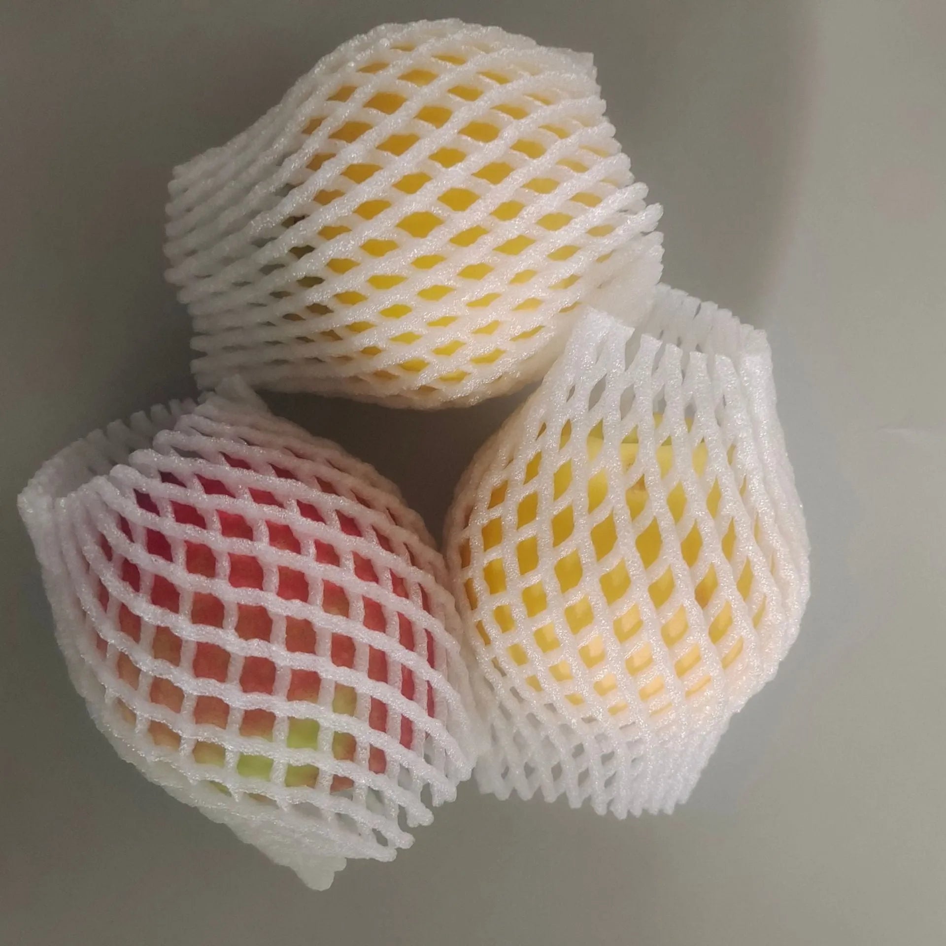 White foam net protective cover for fruit, shown next to an apple, with size options listed.