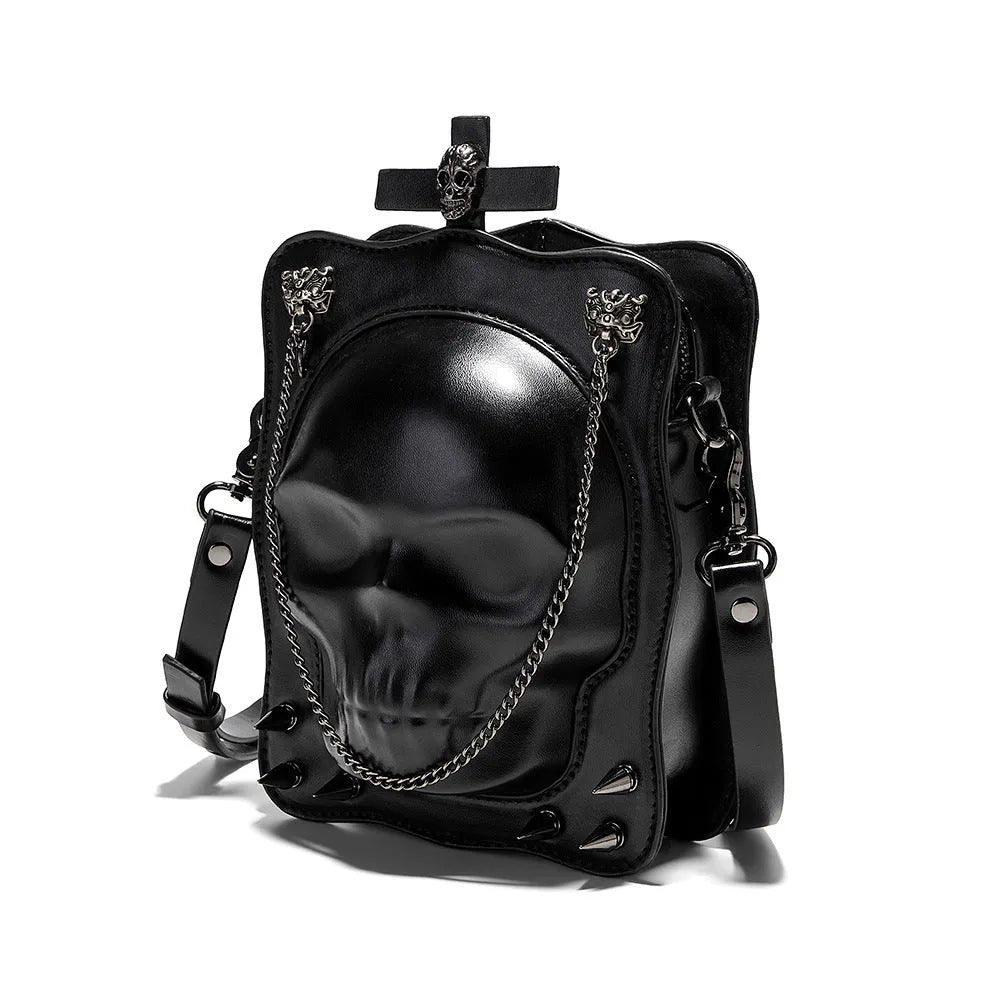 Black mini square crossbody bag with embossed skull design, chain accents, and zipper closure