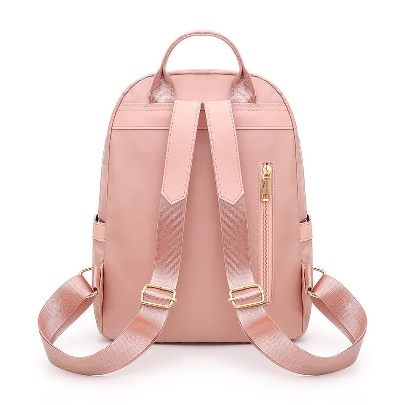 Women's black nylon casual backpack with double shoulder straps, soft handle, and front pocket.