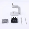 Silver multi-purpose press strap removal tool made from tool steel on a work surface.