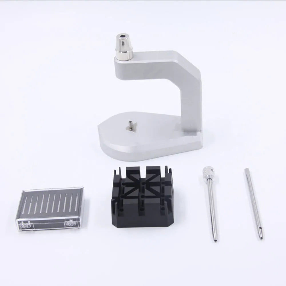 Silver multi-purpose press strap removal tool made from tool steel on a work surface.
