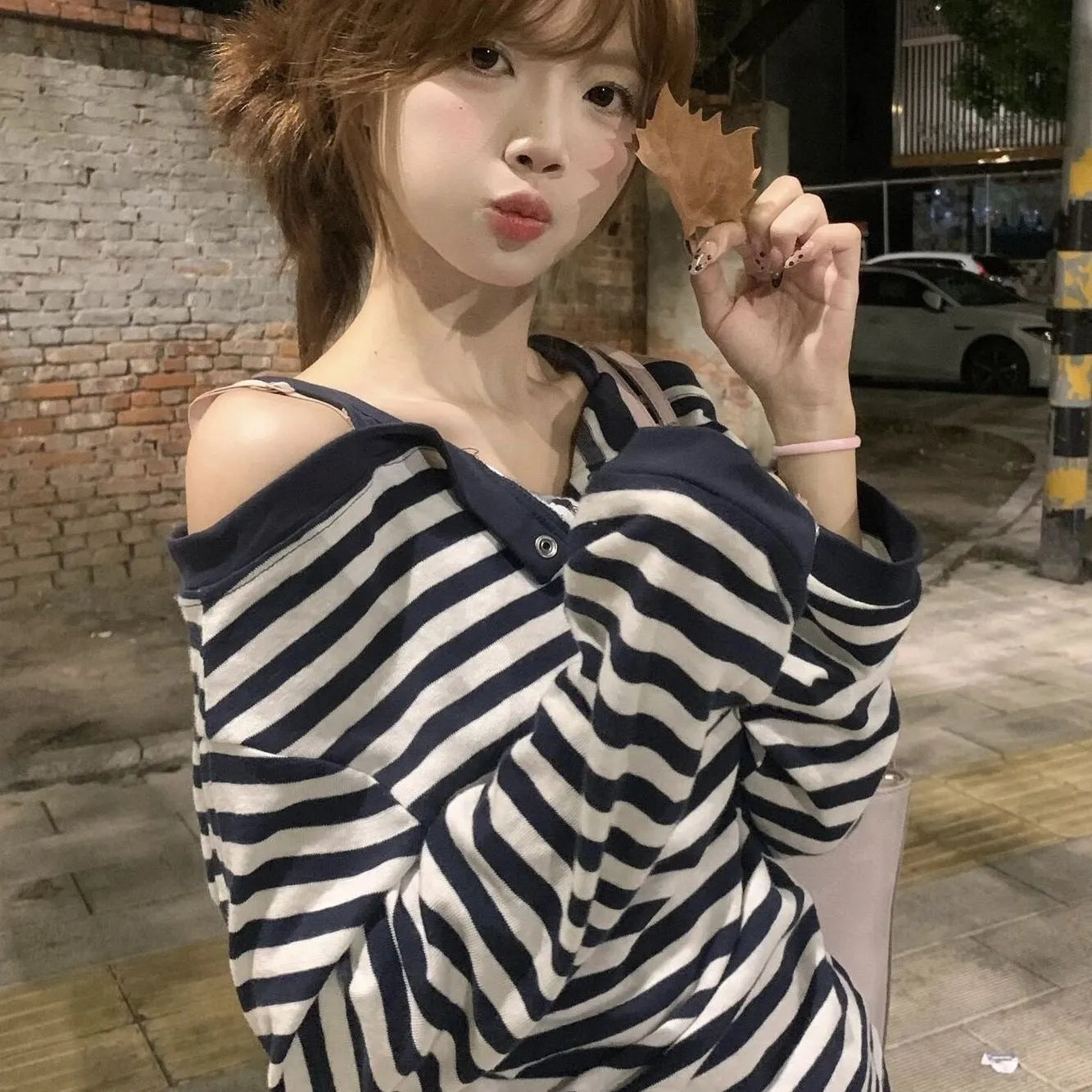 Dark blue women's oversized long-sleeve T-shirt with stripes, buttons, and embroidery details.