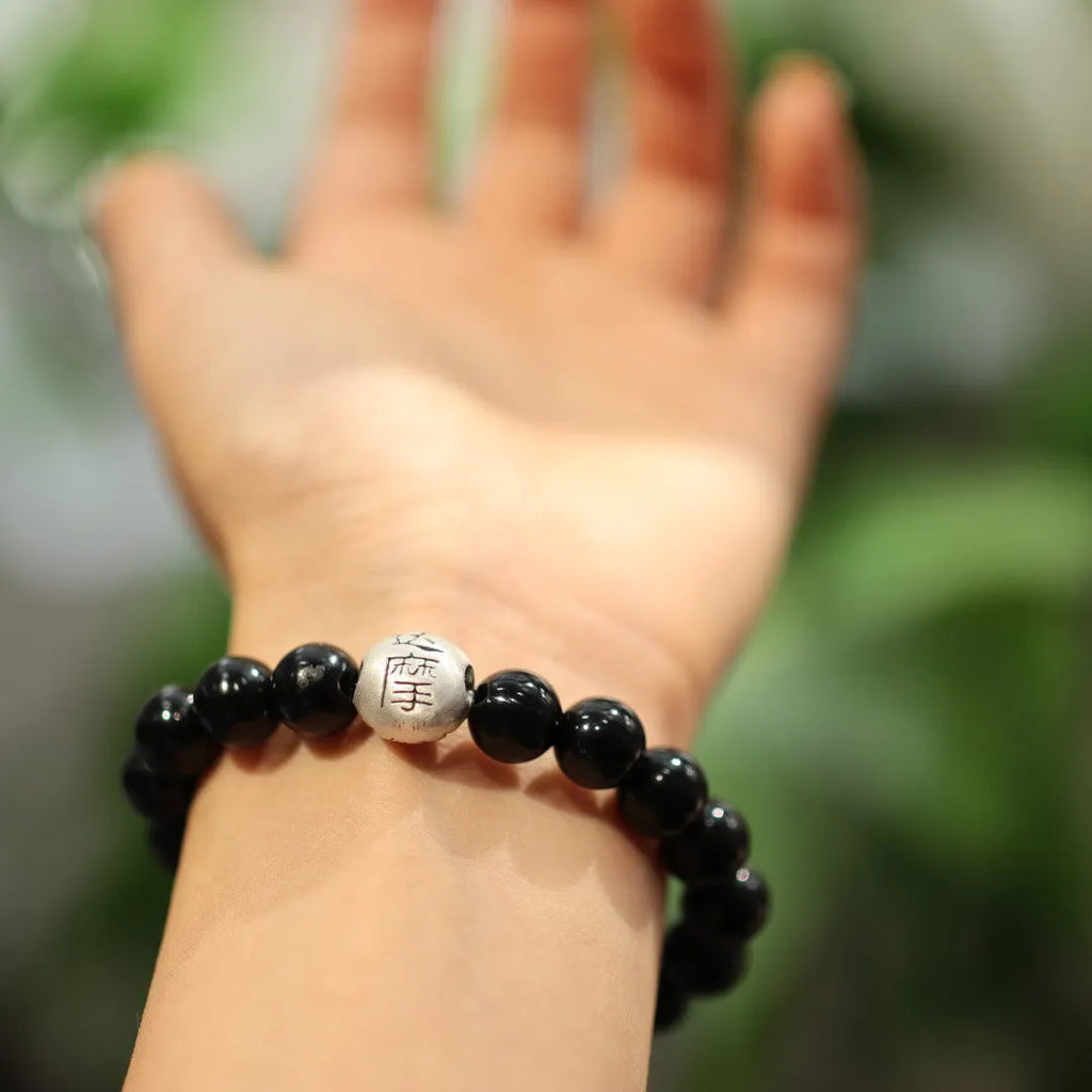 Close-up of a women's bracelet with large 10mm black agate beads on a shiny silver alloy chain in a Chinese style.