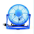 Small black USB desk fan with adjustable head on a wooden desk next to a laptop