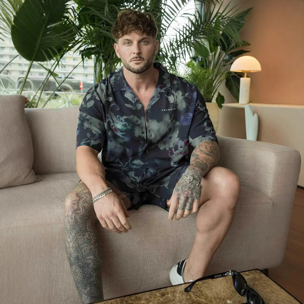 Man wearing a loose grey short-sleeve top with a floral print pattern